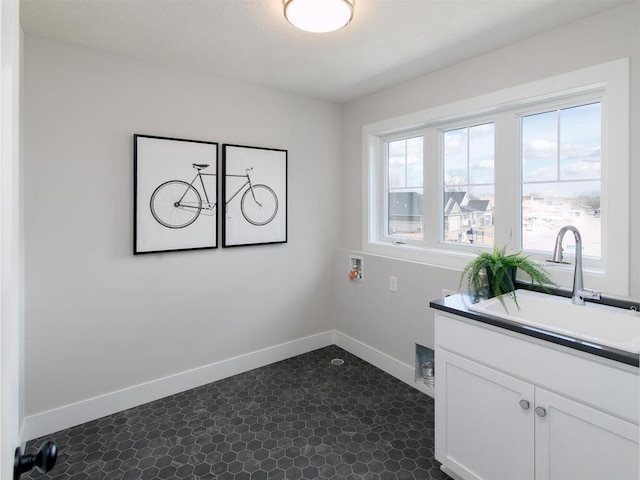 laundry area with washer hookup, cabinet space, baseboards, and a sink