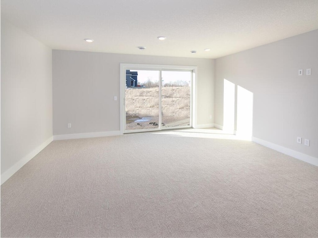 empty room featuring recessed lighting, baseboards, and carpet flooring