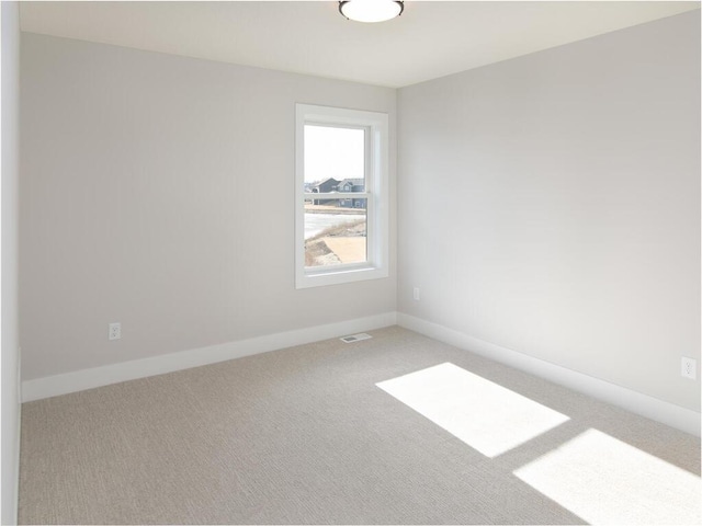 unfurnished room with visible vents, baseboards, and carpet