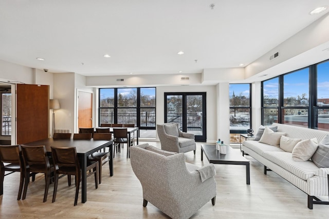 living room featuring light wood-style floors, visible vents, a wealth of natural light, and recessed lighting