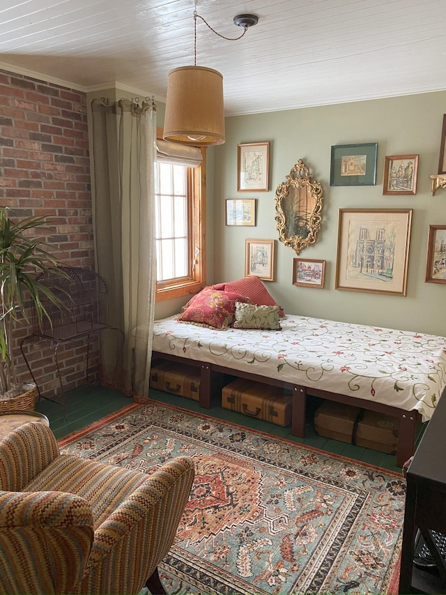 bedroom with crown molding and brick wall