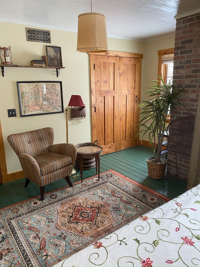 sitting room with wood-type flooring and ornamental molding