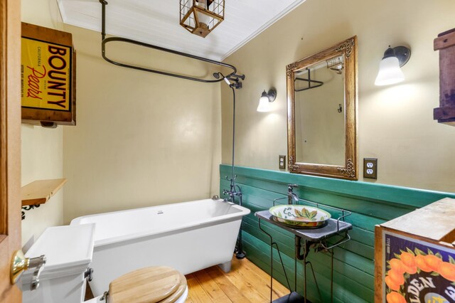 bathroom featuring sink, hardwood / wood-style flooring, a tub, and toilet