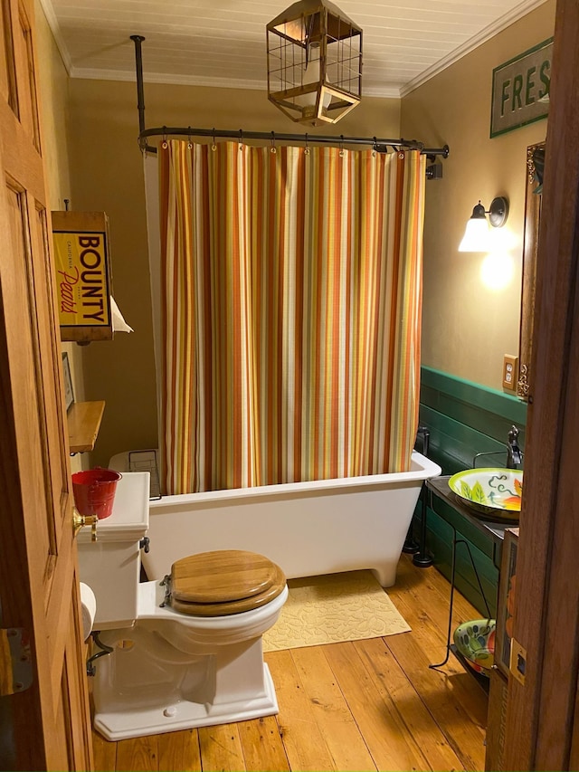 bathroom featuring sink, crown molding, wood-type flooring, and toilet