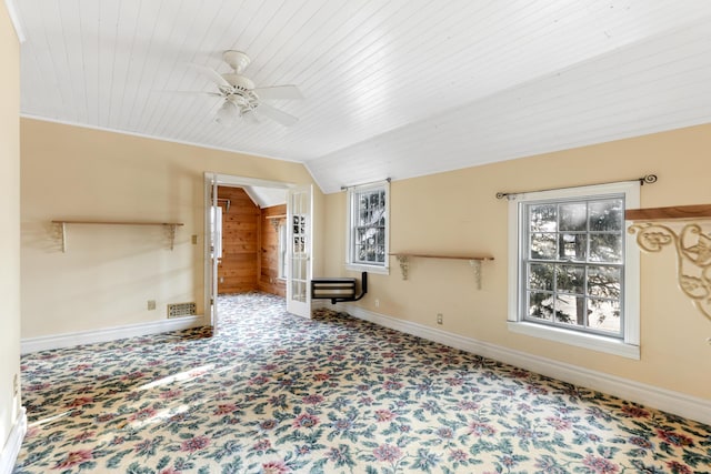 unfurnished living room featuring vaulted ceiling, ceiling fan, wood ceiling, and wood walls