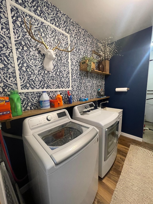 clothes washing area with separate washer and dryer and hardwood / wood-style flooring