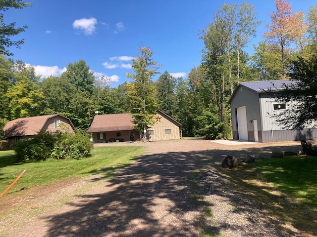 view of property exterior with a garage, a yard, and an outdoor structure