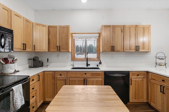 kitchen with black appliances, dark hardwood / wood-style flooring, light brown cabinetry, sink, and butcher block countertops