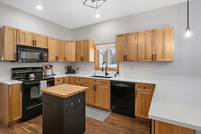 kitchen with black appliances, a center island, dark hardwood / wood-style flooring, sink, and hanging light fixtures