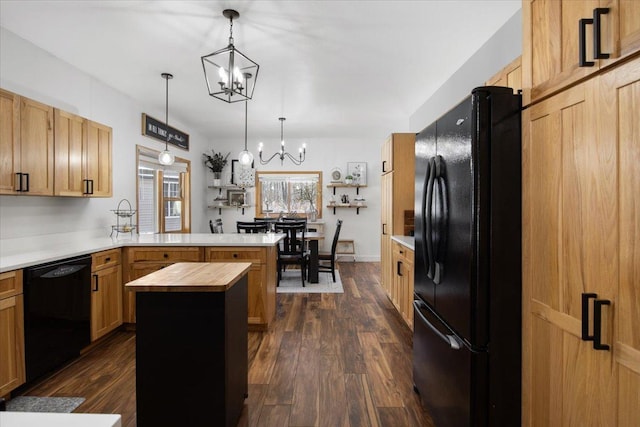 kitchen with dark hardwood / wood-style flooring, a chandelier, a kitchen island, pendant lighting, and black appliances