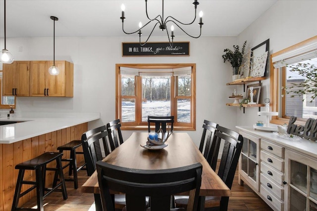 dining space with dark hardwood / wood-style floors and an inviting chandelier