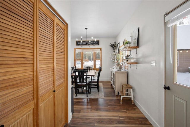 hall with dark hardwood / wood-style flooring and a chandelier