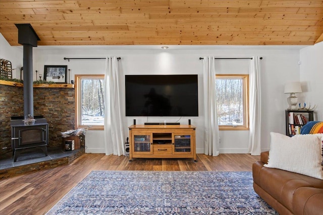 living room featuring wood ceiling, light hardwood / wood-style floors, a wood stove, plenty of natural light, and lofted ceiling