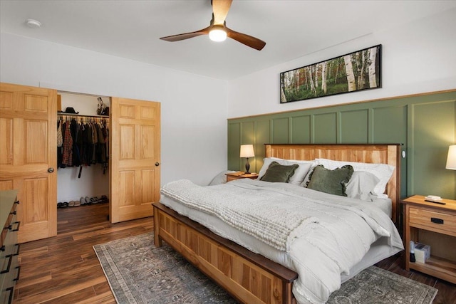 bedroom with ceiling fan, dark wood-type flooring, a closet, and a walk in closet