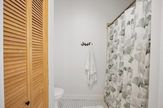 bathroom featuring toilet, tile patterned flooring, and curtained shower