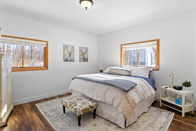 bedroom featuring multiple windows and dark hardwood / wood-style flooring