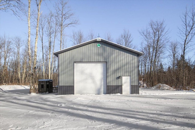 snow covered structure with a garage