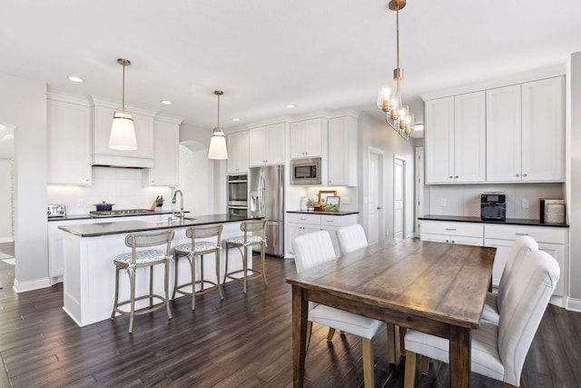 dining room featuring dark wood-style floors, a notable chandelier, and recessed lighting