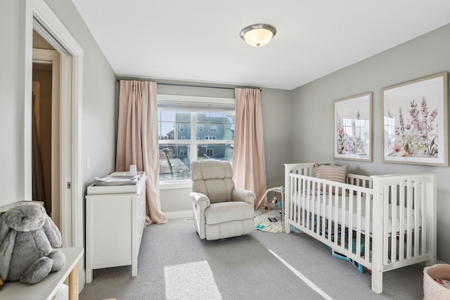 carpeted bedroom with a nursery area and baseboards