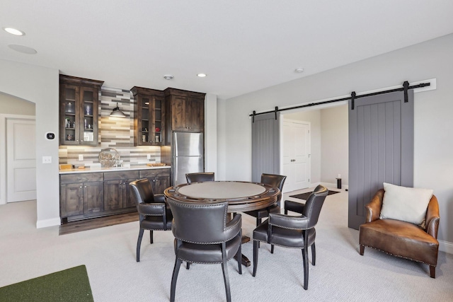 dining room with baseboards, a barn door, light colored carpet, and recessed lighting