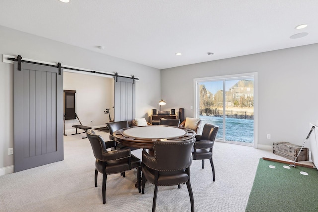 dining room featuring recessed lighting, light colored carpet, baseboards, and a barn door