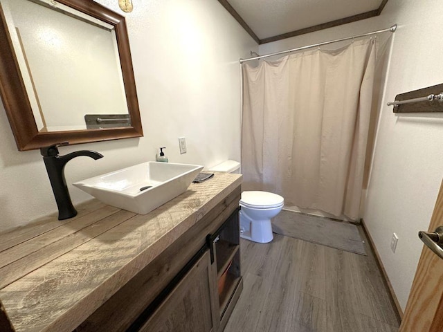 bathroom with a shower with shower curtain, hardwood / wood-style floors, toilet, and ornamental molding