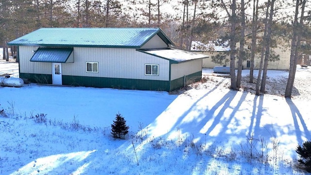 view of snow covered exterior with metal roof