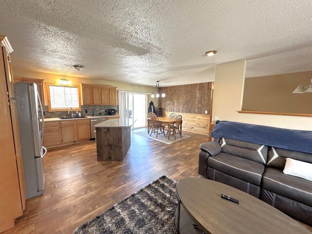 living area with a textured ceiling, wood finished floors, and wooden walls