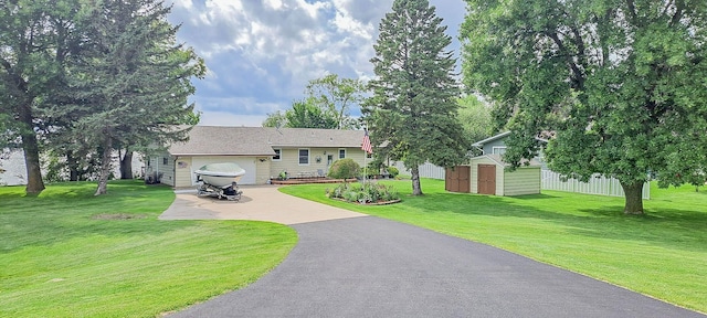 view of front of house with a garage, a shed, and a front lawn