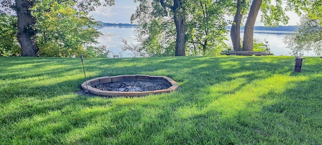 view of yard with a fire pit and a water view