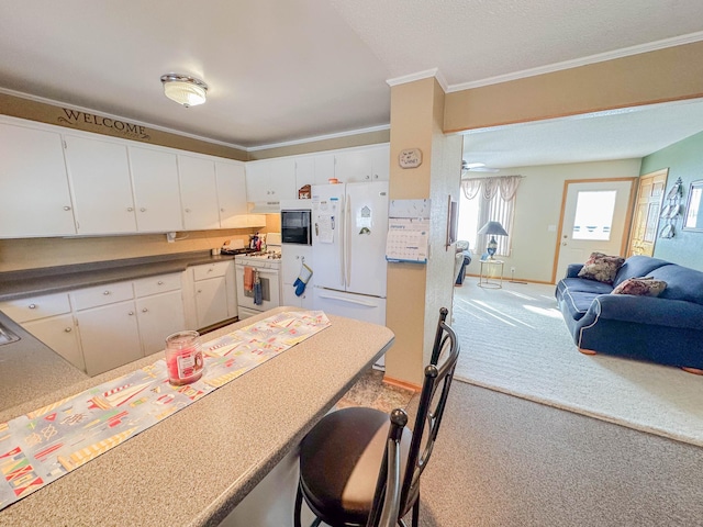 kitchen featuring white appliances, white cabinets, crown molding, carpet flooring, and ceiling fan