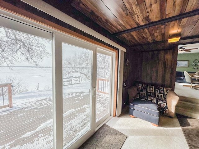 entryway featuring ceiling fan, wood ceiling, and light carpet