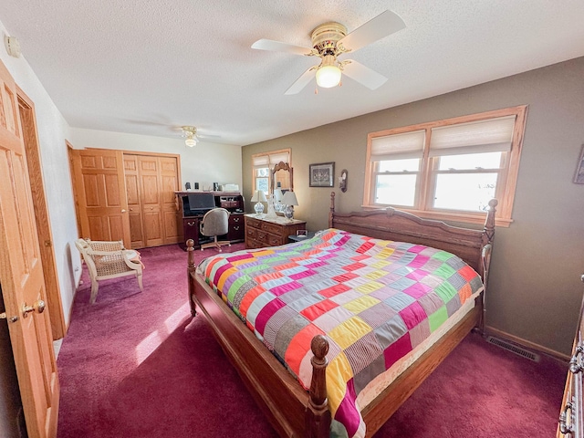 bedroom featuring dark colored carpet, ceiling fan, a textured ceiling, and a closet