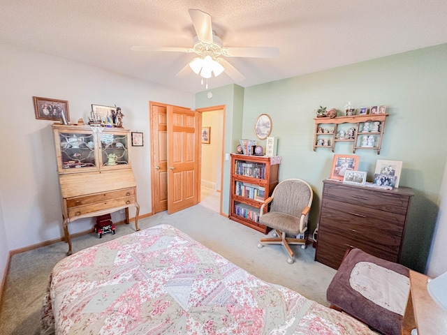 bedroom with ceiling fan, light colored carpet, and a textured ceiling