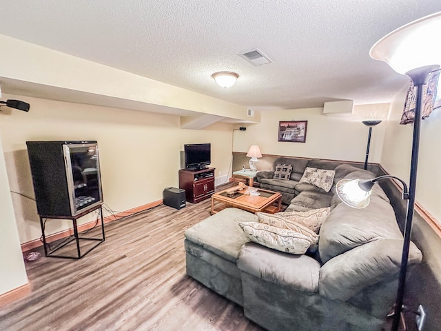 living room with a textured ceiling and hardwood / wood-style flooring