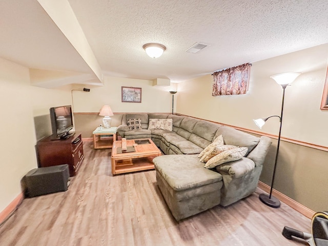 living room featuring light wood-type flooring and a textured ceiling