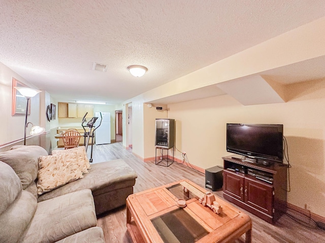 living room featuring light hardwood / wood-style flooring and a textured ceiling