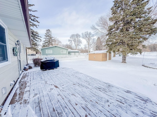 snow covered deck featuring a storage unit