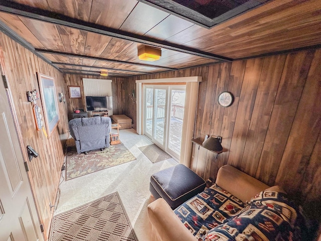 living room with carpet flooring, wooden walls, and wooden ceiling