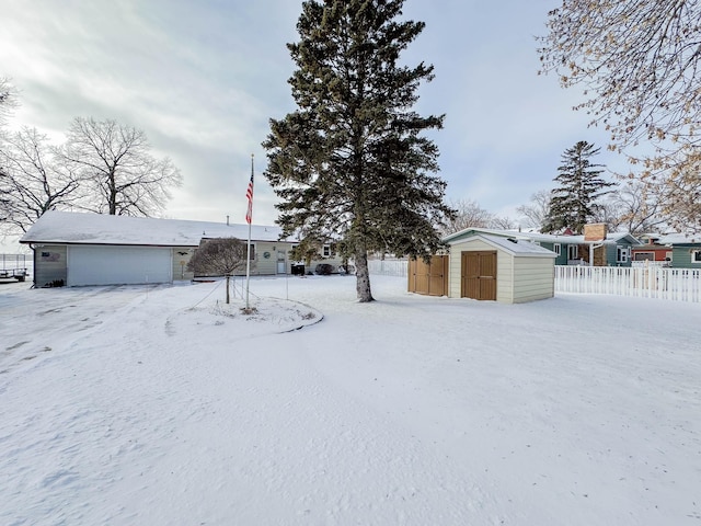view of front of house featuring a garage, an outbuilding, a shed, and fence