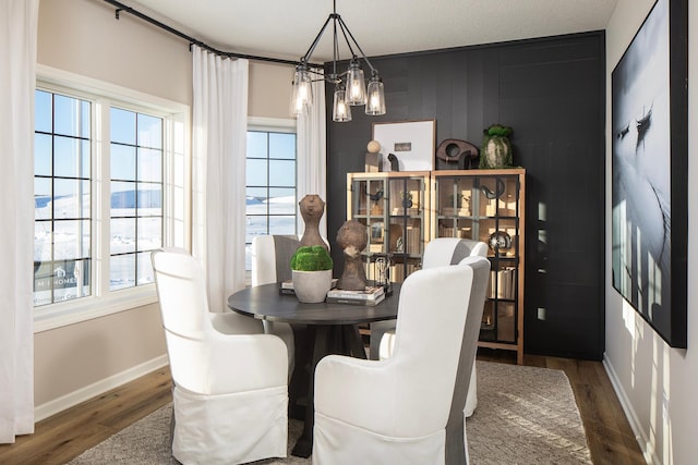 dining room with dark hardwood / wood-style flooring and an inviting chandelier