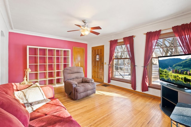 living room with hardwood / wood-style flooring, crown molding, and ceiling fan