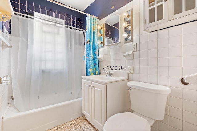 full bathroom with vanity, toilet, tile walls, and shower / bath combo