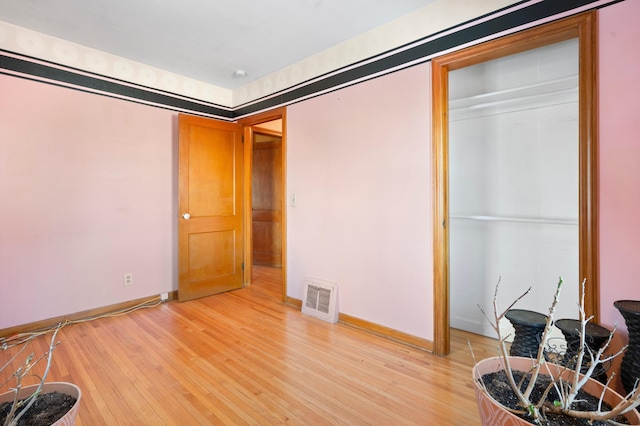 bedroom with light hardwood / wood-style floors and a closet