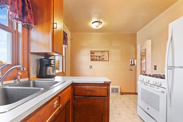 kitchen featuring sink, white appliances, and kitchen peninsula