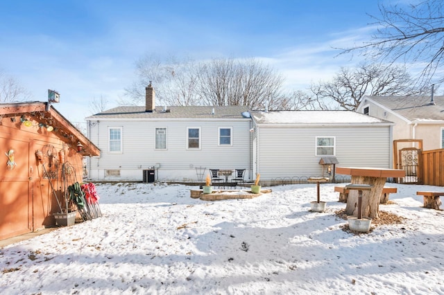 snow covered property with central AC