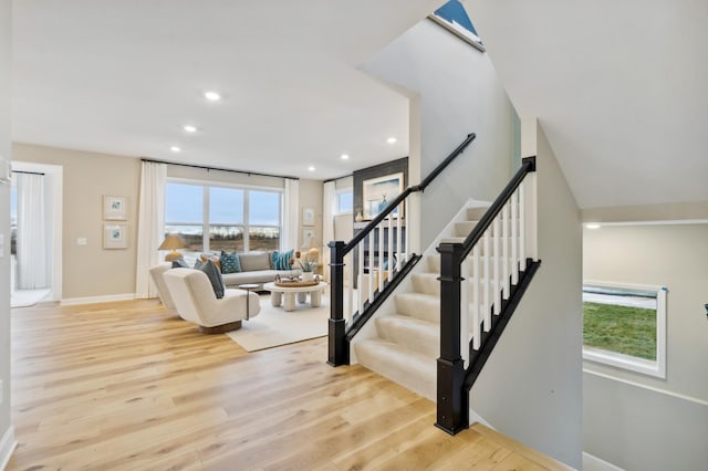 stairs featuring a healthy amount of sunlight and hardwood / wood-style floors