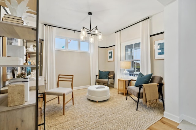 living area featuring a notable chandelier and hardwood / wood-style flooring