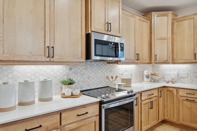 kitchen featuring light brown cabinetry, backsplash, and stainless steel appliances