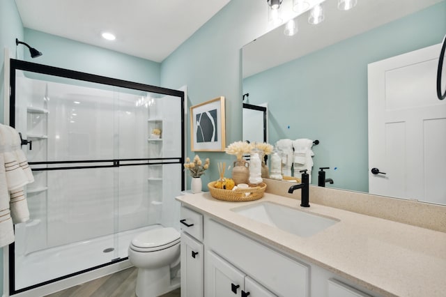 bathroom featuring toilet, walk in shower, hardwood / wood-style flooring, and vanity